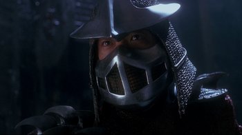Movie still from “Teenage Mutant Ninja Turtles” (1990), directed by Steve Barron – A man wearing a metal helmet and chain mail armor; Close Up shot, Low angle