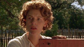 Movie still from “Temple Grandin” (2010), directed by Mick Jackson – A woman with curly blonde hair holding a box; Close Up shot, Over the shoulder angle