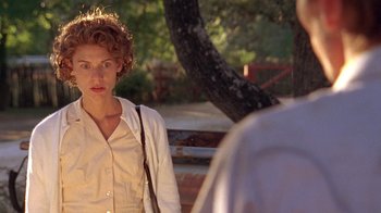 Movie still from “Temple Grandin” (2010), directed by Mick Jackson – A woman standing in front of a tree in a park; Close Up shot, Over the shoulder angle