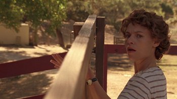 Movie still from “Temple Grandin” (2010), directed by Mick Jackson – A woman standing next to a wooden fence; Close Up shot, Over the shoulder angle