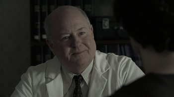 Movie still from “Temple Grandin” (2010), directed by Mick Jackson – An older man wearing a white lab coat; Close Up shot, Over the shoulder angle