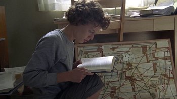 Movie still from “Temple Grandin” (2010), directed by Mick Jackson – A person sitting on the floor reading a book; Medium shot, High angle