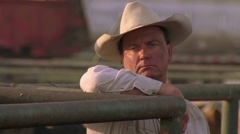 Movie still from “Temple Grandin” (2010), directed by Mick Jackson – A man wearing a cowboy hat leaning on a fence; Close Up shot, Low angle
