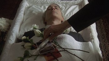 Movie still from “Temple Grandin” (2010), directed by Mick Jackson – A man laying in a bed with a picture of a woman; Close Up shot, Overhead angle
