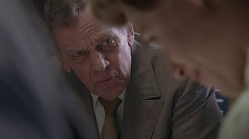 Movie still from “Temple Grandin” (2010), directed by Mick Jackson – An older man wearing a suit and tie looking at the camera; Close Up shot, Over the shoulder angle