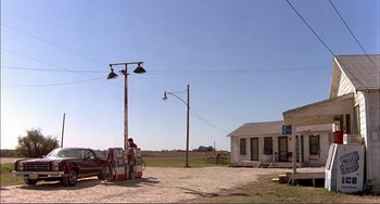 Movie still from “Tender Mercies” (1983), directed by Bruce Beresford – An old gas station with an old truck parked in the middle of the road; Extreme Wide shot, High angle