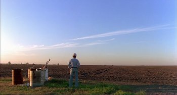 Movie still from “Tender Mercies” (1983), directed by Bruce Beresford – A man standing in the middle of an open field; Extreme Wide shot, Low angle