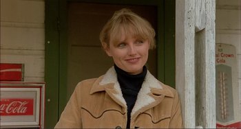 Movie still from “Tender Mercies” (1983), directed by Bruce Beresford – A woman wearing a brown jacket standing in front of a green door; Close Up shot, Low angle