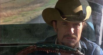 Movie still from “Tender Mercies” (1983), directed by Bruce Beresford – A man in a cowboy hat sitting in the driver's seat of a car; Close Up shot, Low angle