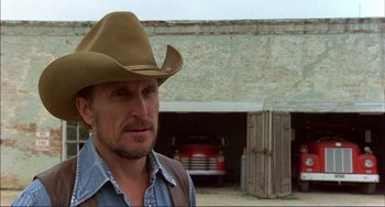 Movie still from “Tender Mercies” (1983), directed by Bruce Beresford – A man wearing a cowboy hat standing in front of a garage; Close Up shot, Low angle