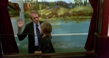 Movie still from “Tender Mercies” (1983), directed by Bruce Beresford – A man and a boy in front of a painting of a lake; Medium shot, Over the shoulder angle