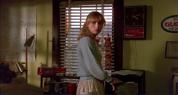 Movie still from “Tender Mercies” (1983), directed by Bruce Beresford – A woman standing in front of a window holding a can of soda; Medium shot, Low angle