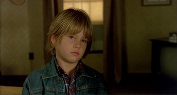 Movie still from “Tender Mercies” (1983), directed by Bruce Beresford – A young boy with long blonde hair wearing a jean jacket; Close Up shot, Low angle