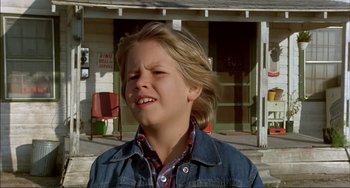 Movie still from “Tender Mercies” (1983), directed by Bruce Beresford – A young boy in a plaid shirt and denim jacket; Close Up shot, Low angle