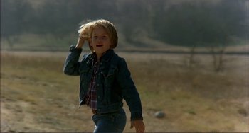 Movie still from “Tender Mercies” (1983), directed by Bruce Beresford – A young boy is walking in a field; Medium shot, Low angle