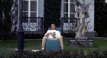 Movie still from “Teorema” (1968), directed by Pier Paolo Pasolini – A man sitting in a chair reading a book; Wide shot, Low angle