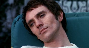 Movie still from “Teorema” (1968), directed by Pier Paolo Pasolini – A person sitting in a chair; Close Up shot, Low angle