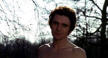 Movie still from “Teorema” (1968), directed by Pier Paolo Pasolini – A shirtless man with a tree in the background; Close Up shot, Low angle