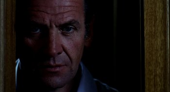 Movie still from “Teorema” (1968), directed by Pier Paolo Pasolini – A man's face in the dark; Close Up shot, Low angle