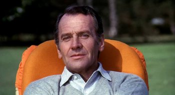 Movie still from “Teorema” (1968), directed by Pier Paolo Pasolini – An older man sitting in an orange chair; Close Up shot, Low angle