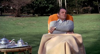 Movie still from “Teorema” (1968), directed by Pier Paolo Pasolini – A man sitting in a lawn chair with a blanket over him; Medium shot, High angle