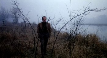 Movie still from “Teorema” (1968), directed by Pier Paolo Pasolini – A man standing in the middle of a dry grass field; Medium shot, Low angle