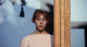Movie still from “Teorema” (1968), directed by Pier Paolo Pasolini – A woman standing in front of a wooden door; Close Up shot, Low angle