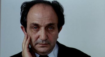 Movie still from “Teorema” (1968), directed by Pier Paolo Pasolini – An older man in a black suit and tie; Close Up shot, Low angle