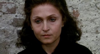 Movie still from “Teorema” (1968), directed by Pier Paolo Pasolini – A woman's face in front of a brick wall; Close Up shot, High angle