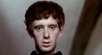 Movie still from “Teorema” (1968), directed by Pier Paolo Pasolini – A young man with curly red hair is looking at the camera; Close Up shot, Low angle