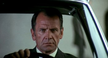 Movie still from “Teorema” (1968), directed by Pier Paolo Pasolini – A person in a suit driving a car; Close Up shot, Low angle