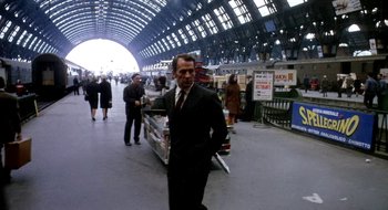 Movie still from “Teorema” (1968), directed by Pier Paolo Pasolini – A man in a suit walking through a train station; Wide shot, Low angle