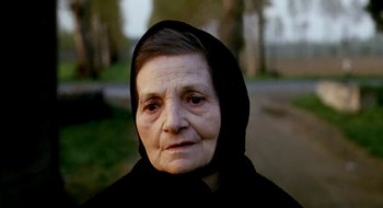 Movie still from “Teorema” (1968), directed by Pier Paolo Pasolini – An older woman wearing a black head covering; Close Up shot, Low angle