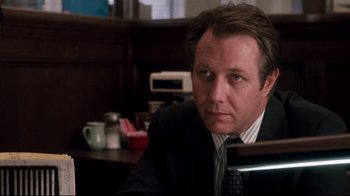 Movie still from “Tequila Sunrise” (1988), directed by Robert Towne – A person wearing a suit and tie; Close Up shot, Over the shoulder angle