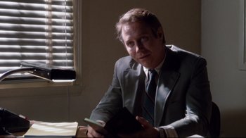 Movie still from “Tequila Sunrise” (1988), directed by Robert Towne – A man sitting at a table in a suit and tie; Close Up shot, Over the shoulder angle