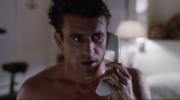Movie still from “Tequila Sunrise” (1988), directed by Robert Towne – A shirtless man holding a cell phone to his ear; Close Up shot, Low angle