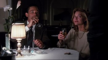 Movie still from “Tequila Sunrise” (1988), directed by Robert Towne – A man and a woman sitting at a table drinking wine; Medium shot, Low angle