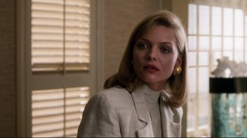 Movie still from “Tequila Sunrise” (1988), directed by Robert Towne – A woman in a white jacket and a pair of gold earrings; Close Up shot, Over the shoulder angle