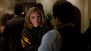 Movie still from “Tequila Sunrise” (1988), directed by Robert Towne – A woman sitting next to a man in a room; Medium shot, Over the shoulder angle