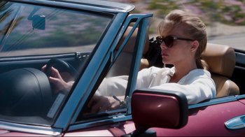 Movie still from “Tequila Sunrise” (1988), directed by Robert Towne – A woman driving a car in the road; Medium shot, Low angle