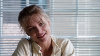 Movie still from “Tequila Sunrise” (1988), directed by Robert Towne – A woman sitting in front of a window smiling for the camera; Close Up shot, Low angle