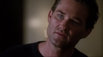 Movie still from “Tequila Sunrise” (1988), directed by Robert Towne – A man's face in a black shirt; Close Up shot, Over the shoulder angle