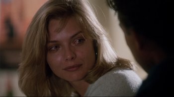 Movie still from “Tequila Sunrise” (1988), directed by Robert Towne – A person sitting down looking at the camera; Close Up shot, Over the shoulder angle