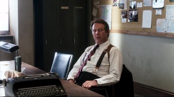 Movie still from “Tequila Sunrise” (1988), directed by Robert Towne – A man sitting at a desk in front of an open laptop computer; Medium shot, Over the shoulder angle