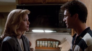 Movie still from “Tequila Sunrise” (1988), directed by Robert Towne – A man and a woman are standing in front of a microwave; Close Up shot, Low angle