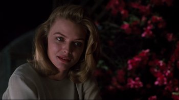 Movie still from “Tequila Sunrise” (1988), directed by Robert Towne – A woman with blonde hair is smiling for the camera; Close Up shot, Over the shoulder angle