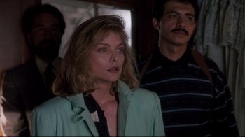 Movie still from “Tequila Sunrise” (1988), directed by Robert Towne – A woman standing next to a man in a room; Close Up shot, Over the shoulder angle