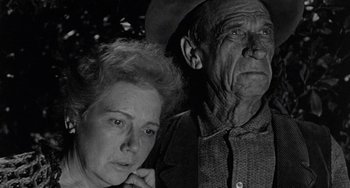 Movie still from “Terror in a Texas Town” (1958), directed by Joseph H. Lewis – An older man and a younger woman looking at the camera; Close Up shot, Low angle