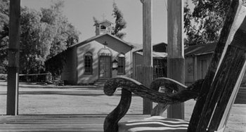 Movie still from “Terror in a Texas Town” (1958), directed by Joseph H. Lewis – An old wooden bench in front of an old church; Wide shot, Low angle