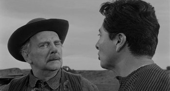 Movie still from “Terror in a Texas Town” (1958), directed by Joseph H. Lewis – A man and a woman talking to each other in a black and white photo; Close Up shot, Over the shoulder angle